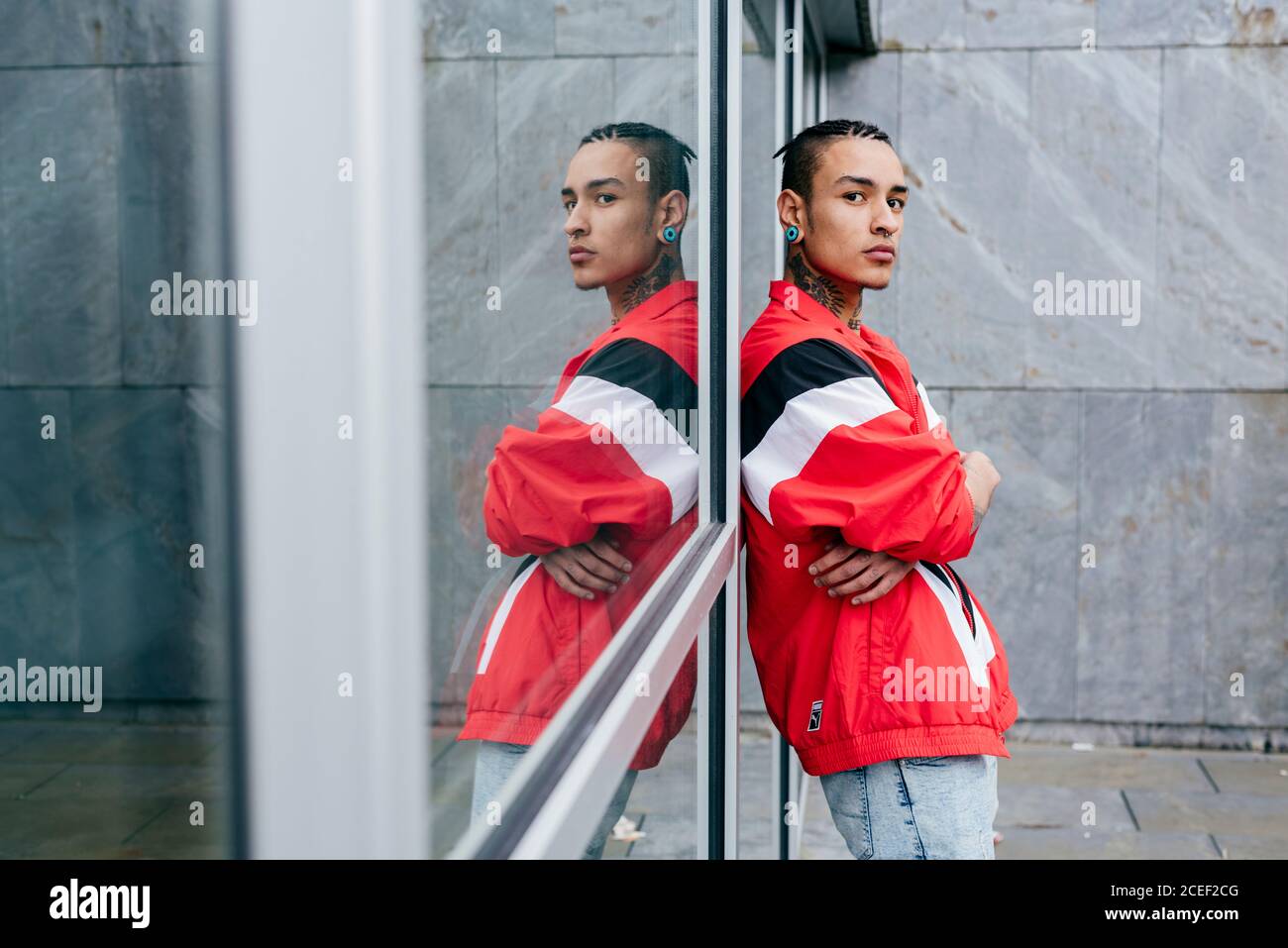 Hipster leaning against mirror wall Stock Photo Alamy