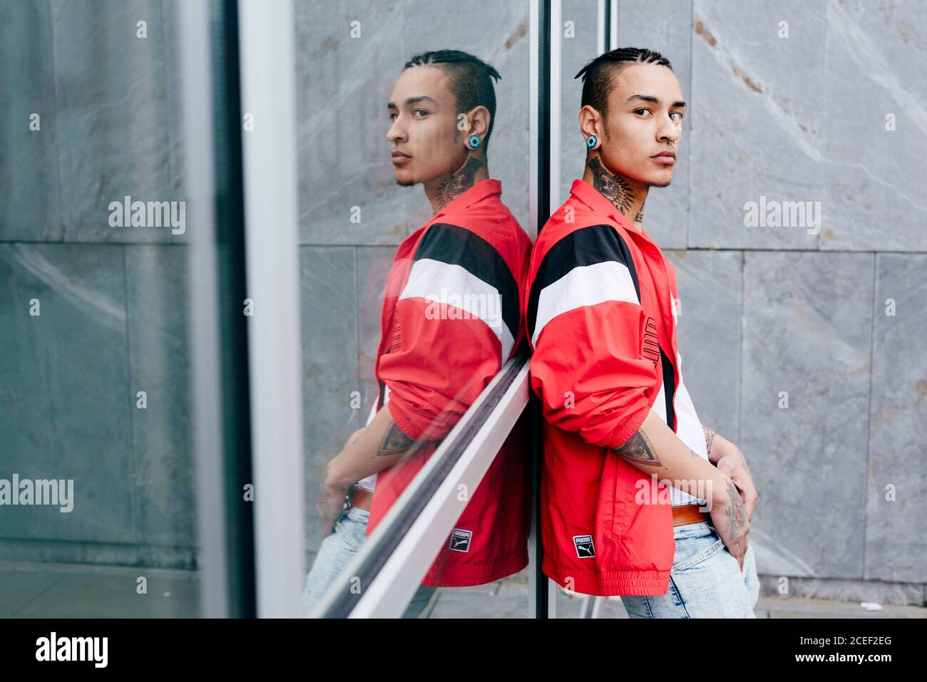 Hipster leaning against mirror wall Stock Photo Alamy