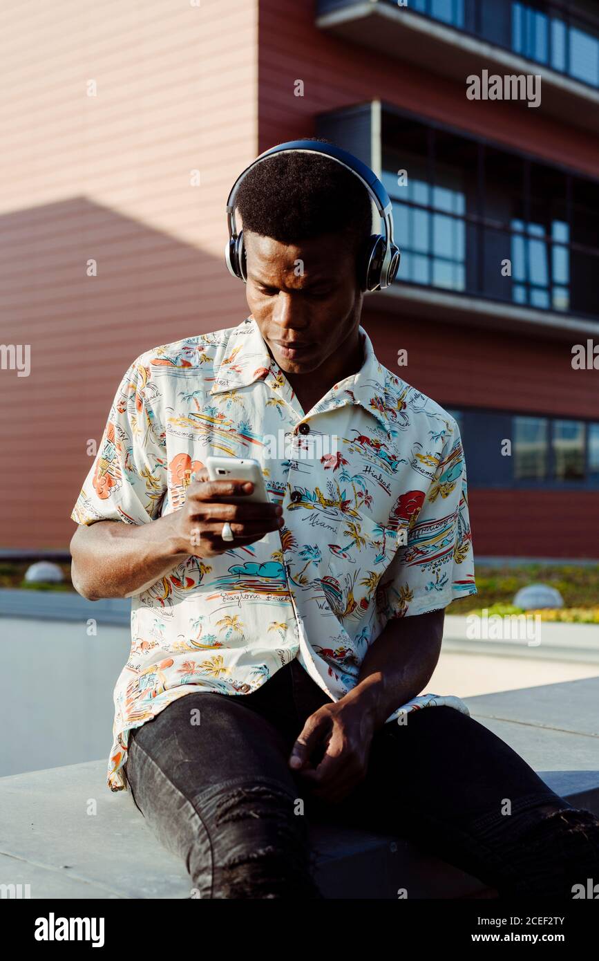 Black man in headphones using smartphone Stock Photo