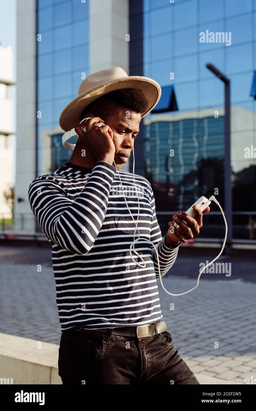 Black man in headphones using smartphone Stock Photo