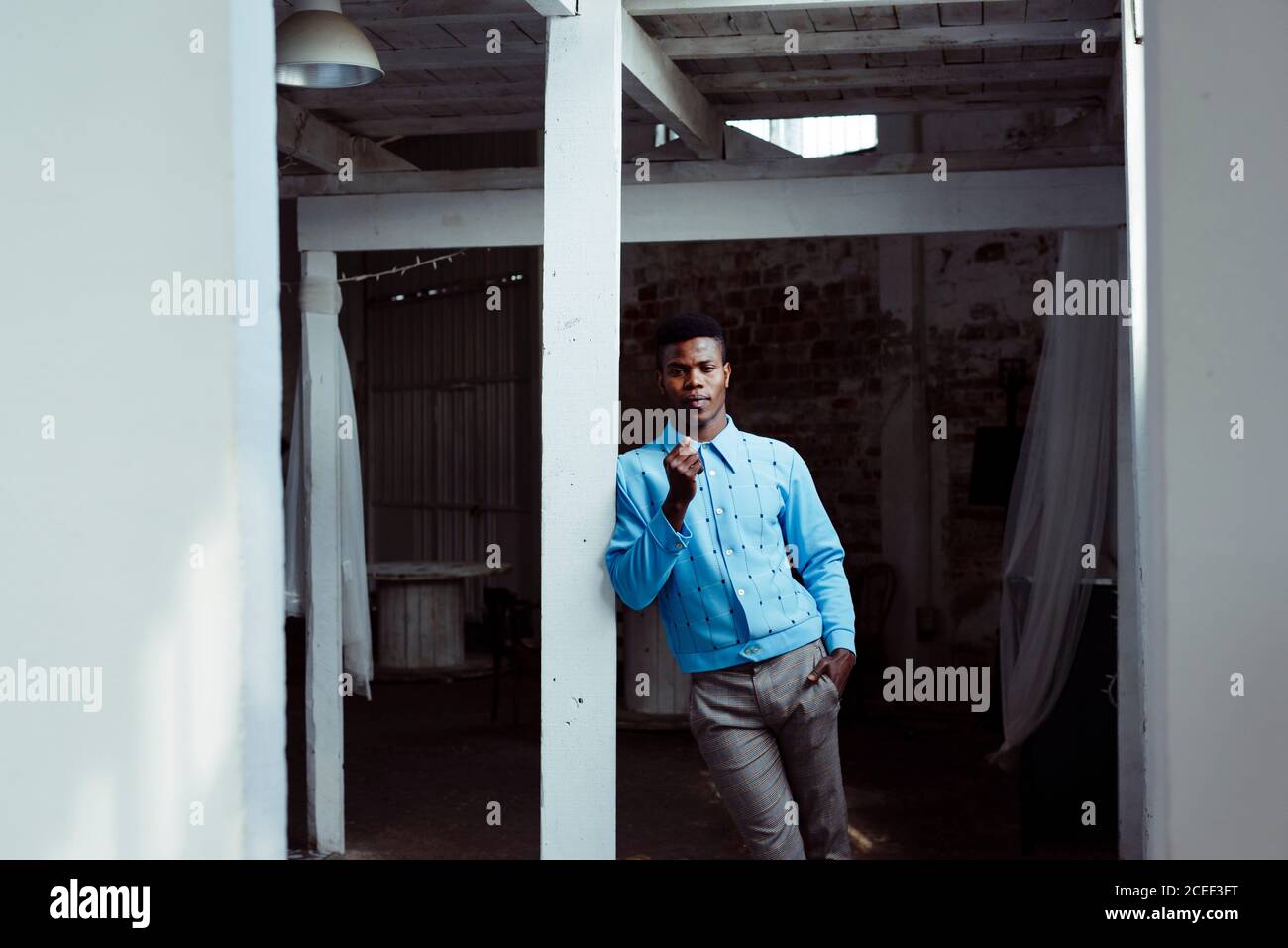 Stylish black man leaning on wall Stock Photo