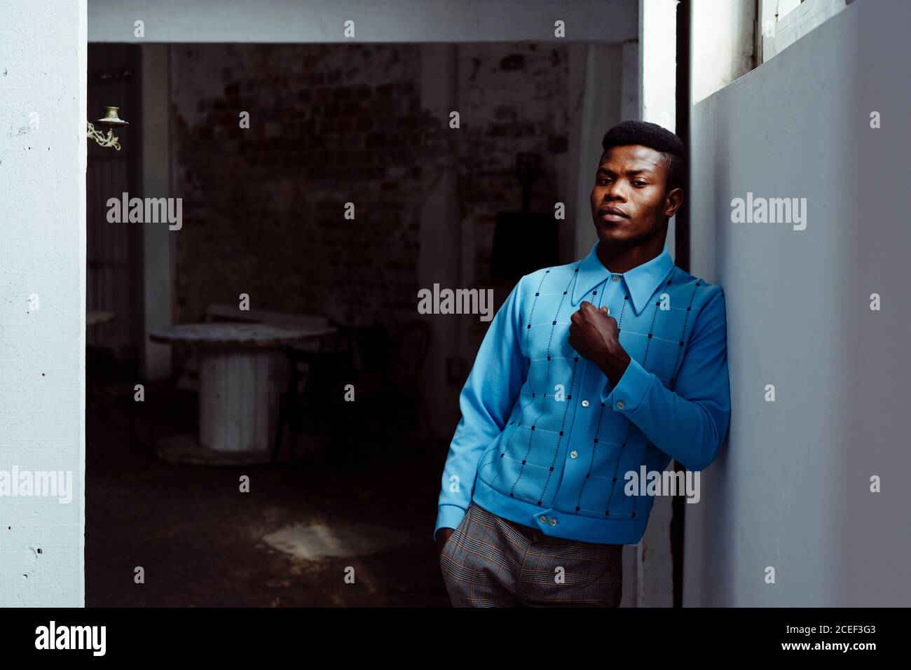 Stylish black man leaning on wall Stock Photo