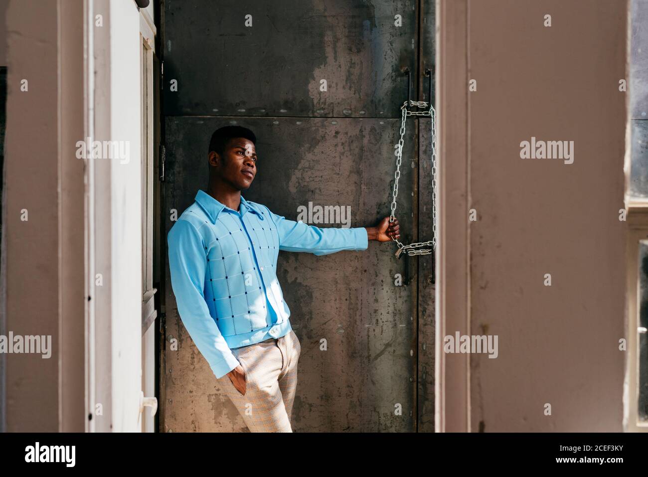 African-American man looking out dirty window Stock Photo