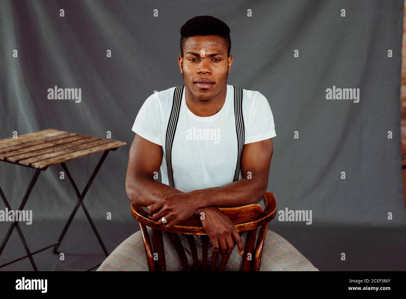 Stylish black man sitting near table Stock Photo