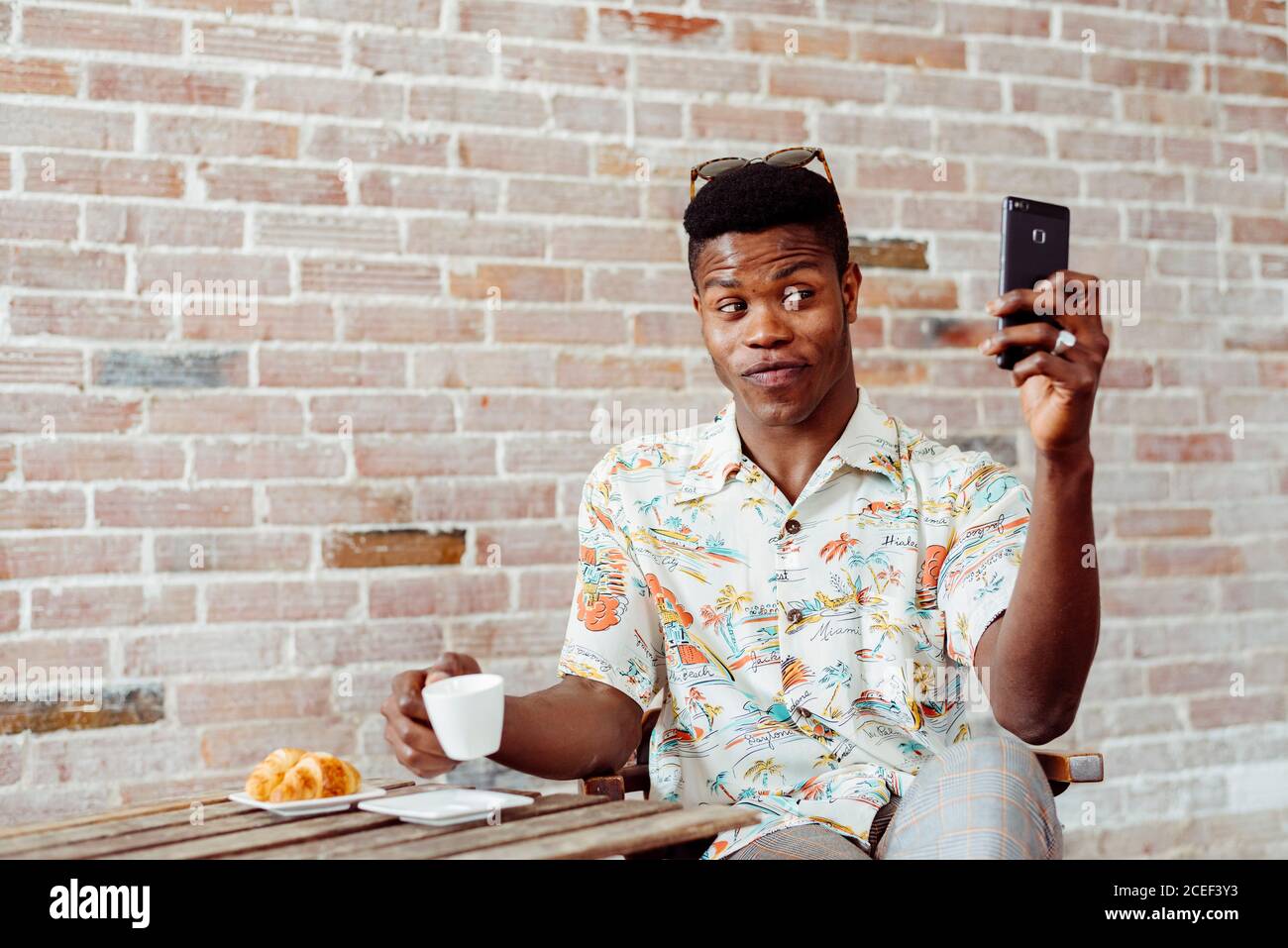 man using smartphone during breakfast Stock Photo