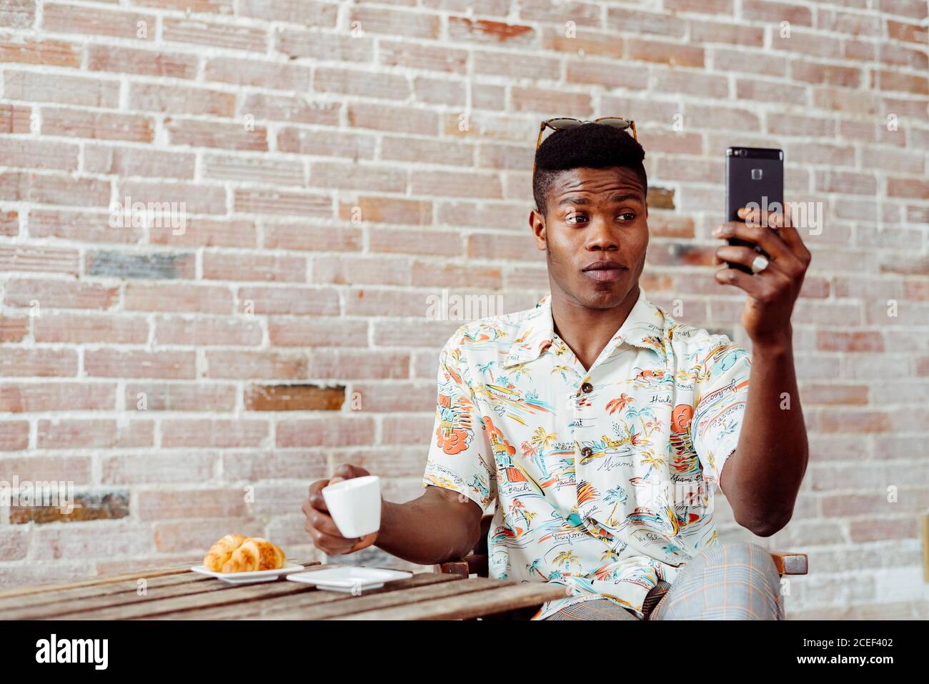 man using smartphone during breakfast Stock Photo
