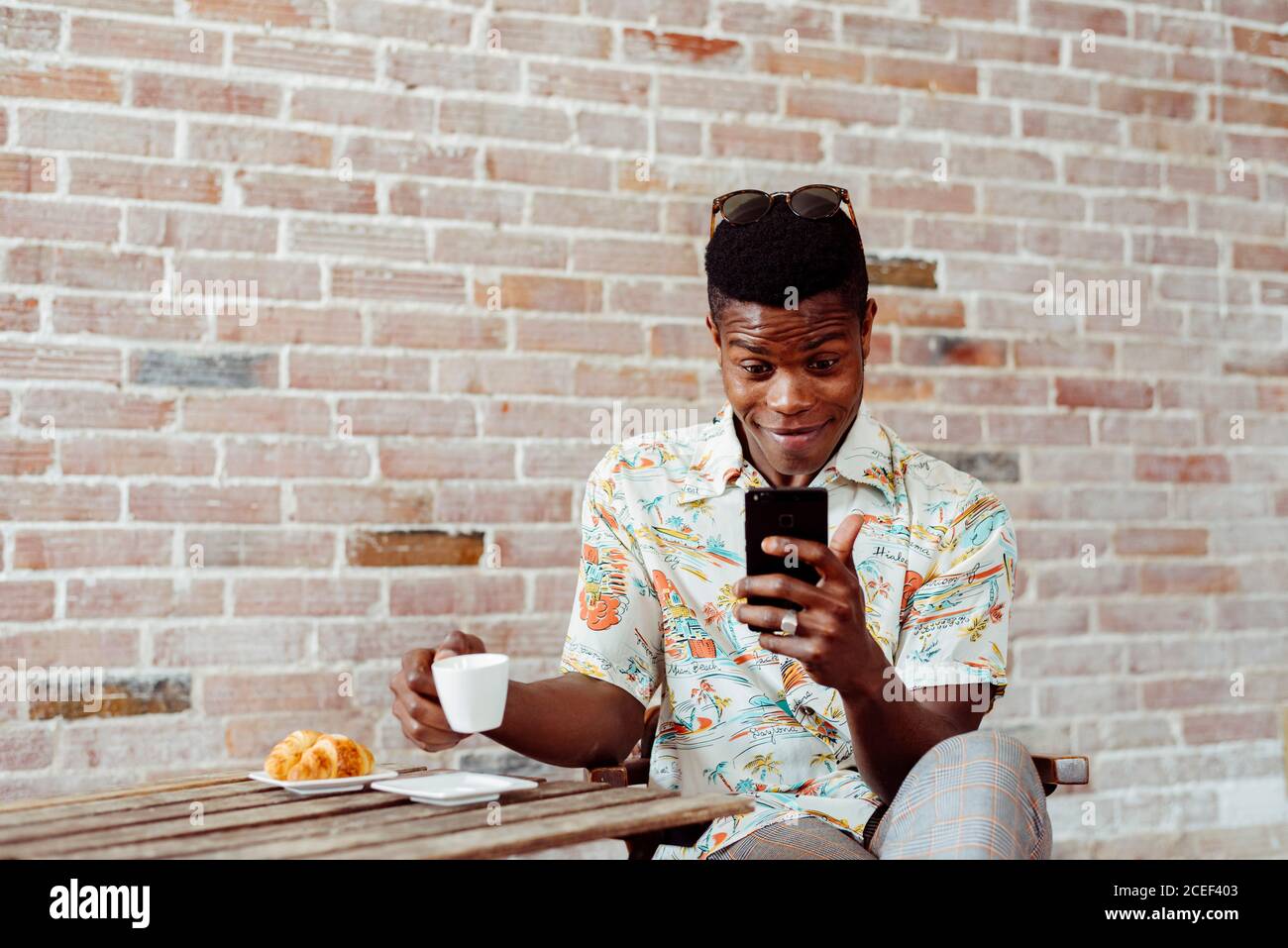 man using smartphone during breakfast Stock Photo