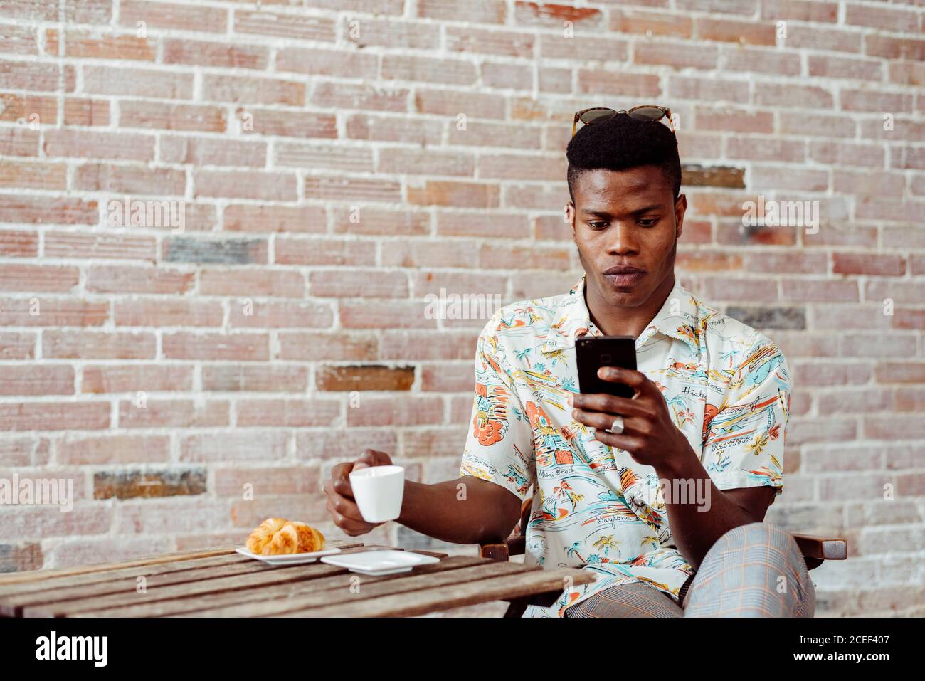 man using smartphone during breakfast Stock Photo