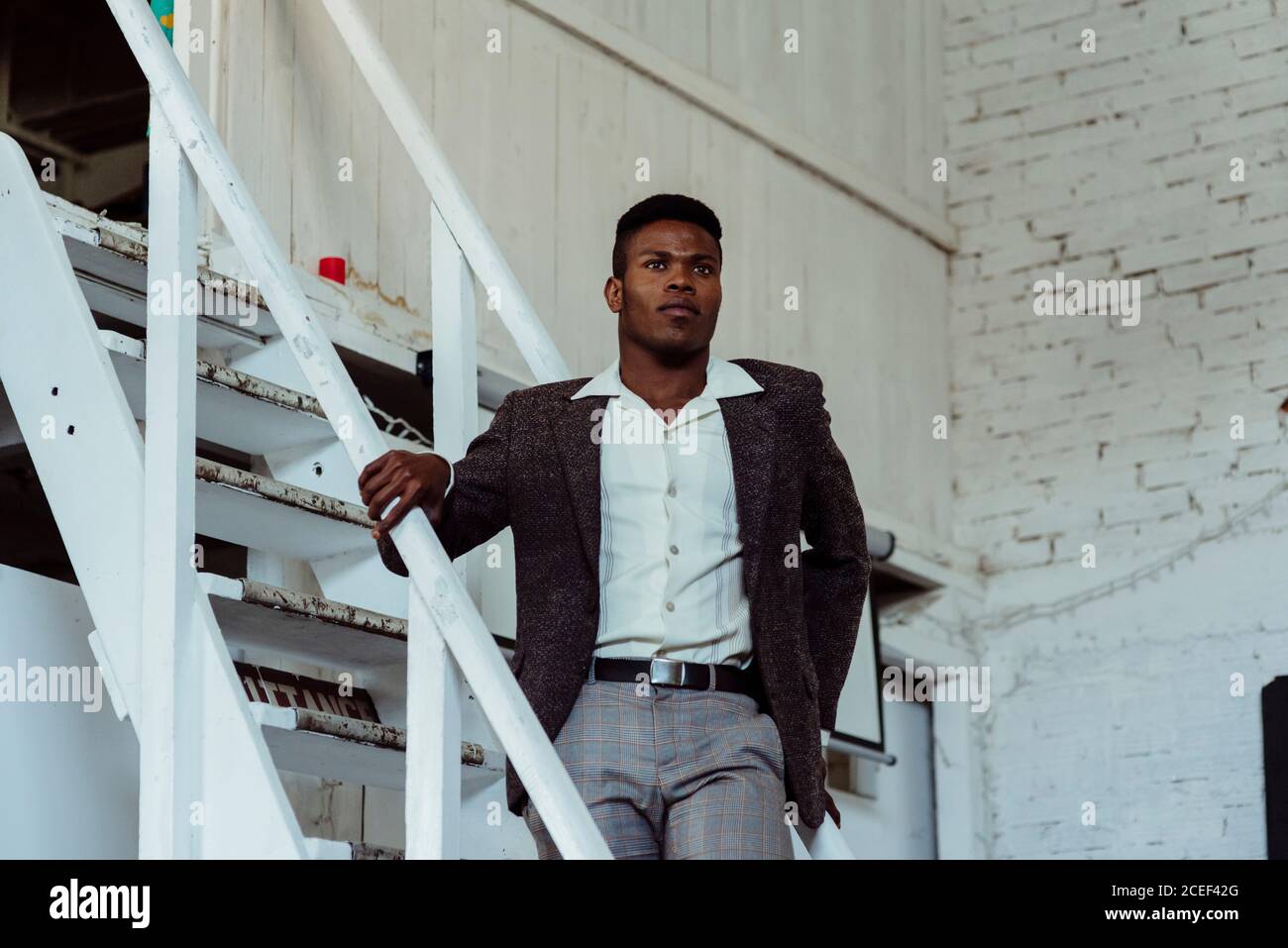Black man standing on ladder Stock Photo