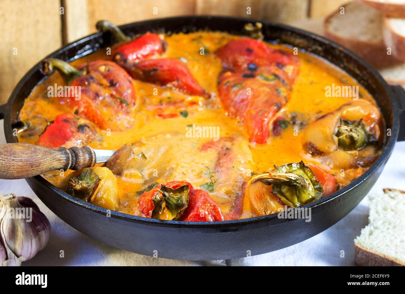 Sweet peppers in tomato and sour cream sauce, a traditional dish in some European countries. Rustic style. Stock Photo