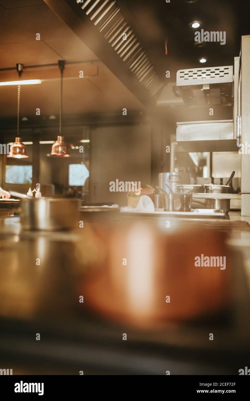 The kitchen of a restaurant with the pots on the stoves. Vertical indoors shot. Stock Photo