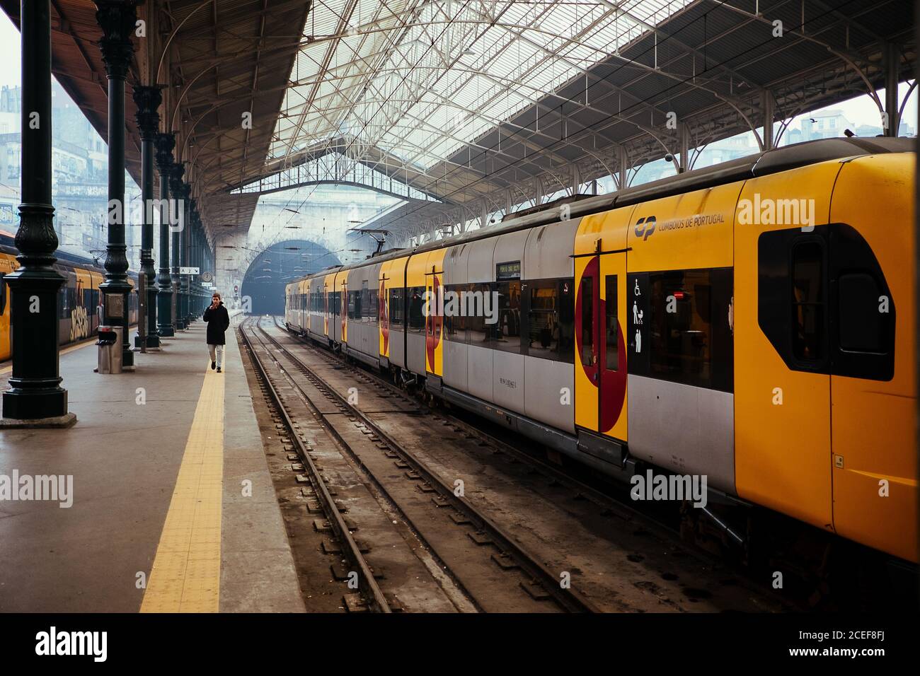 PORTO, PORTUGAL - February, 11, 2019 : Distant traveler walking on platform of railway station near modern train in Porto, Portugal Stock Photo