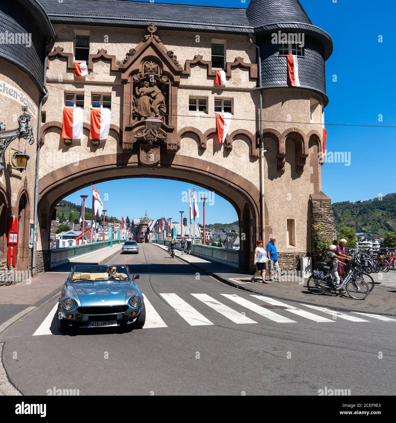 Traben-Trarbach, Rheinland-Pfalz / Germany - 31 July 2020: attractive woman driving a convertible through the Brueckentor Gate in Traben on a summer d Stock Photo