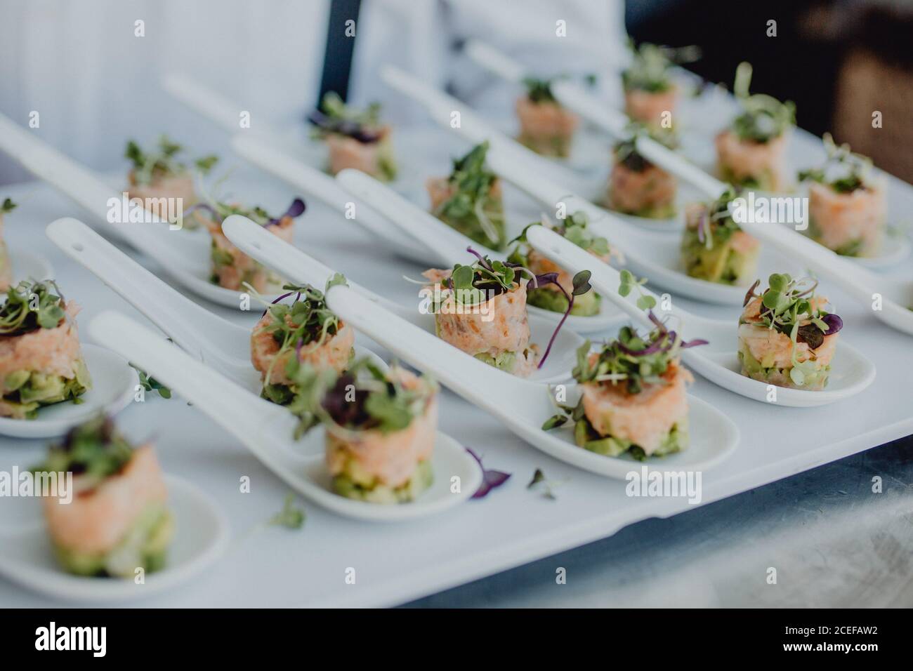 Small spoons with palatable canapes lying on tray during banquet Stock Photo