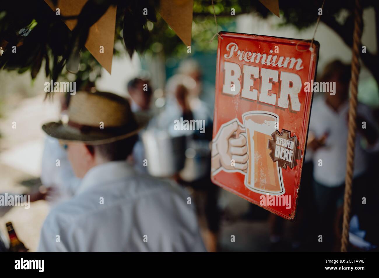 Sign of beer bar hanging on blurred background of people on party Stock Photo