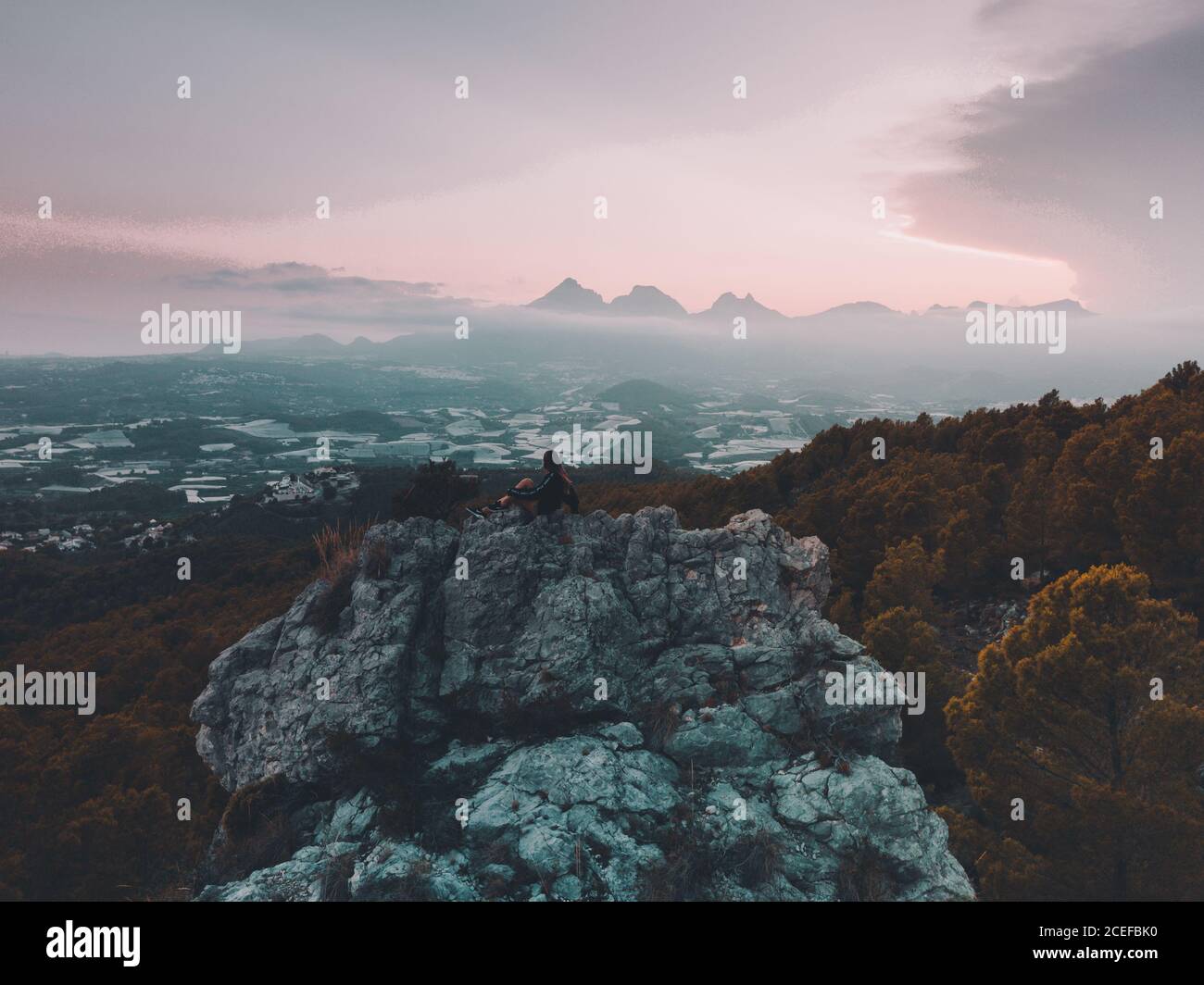 anonymous Woman sitting on rock Stock Photo