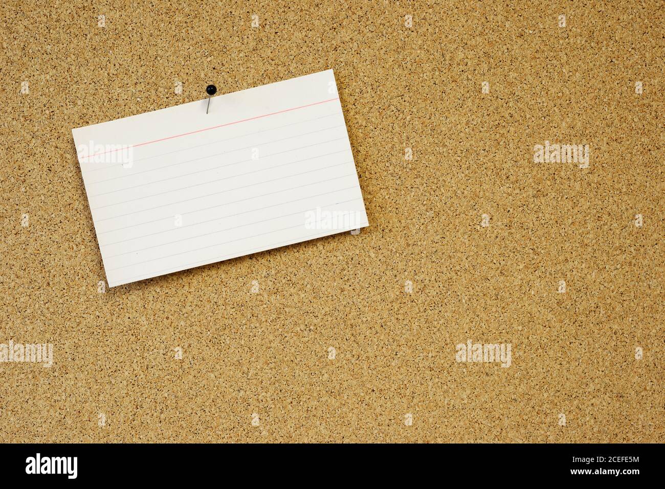 sticky note card pinned to cork board Stock Photo