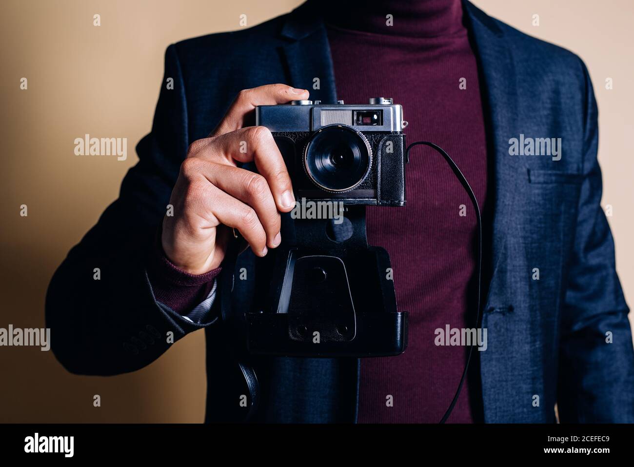 Young man in a studio holding a vintage camera Stock Photo