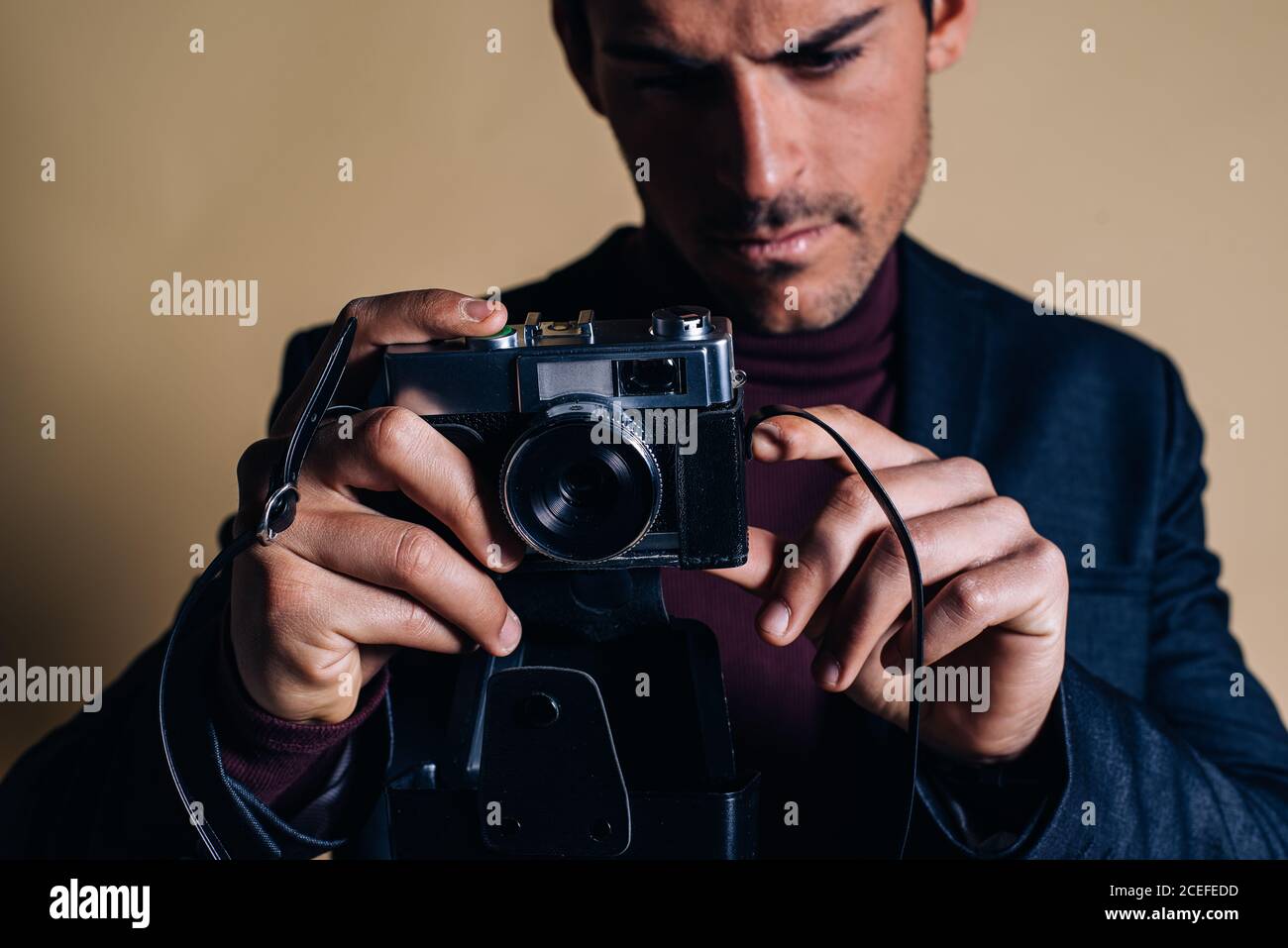 Young man in a studio holding a vintage camera Stock Photo