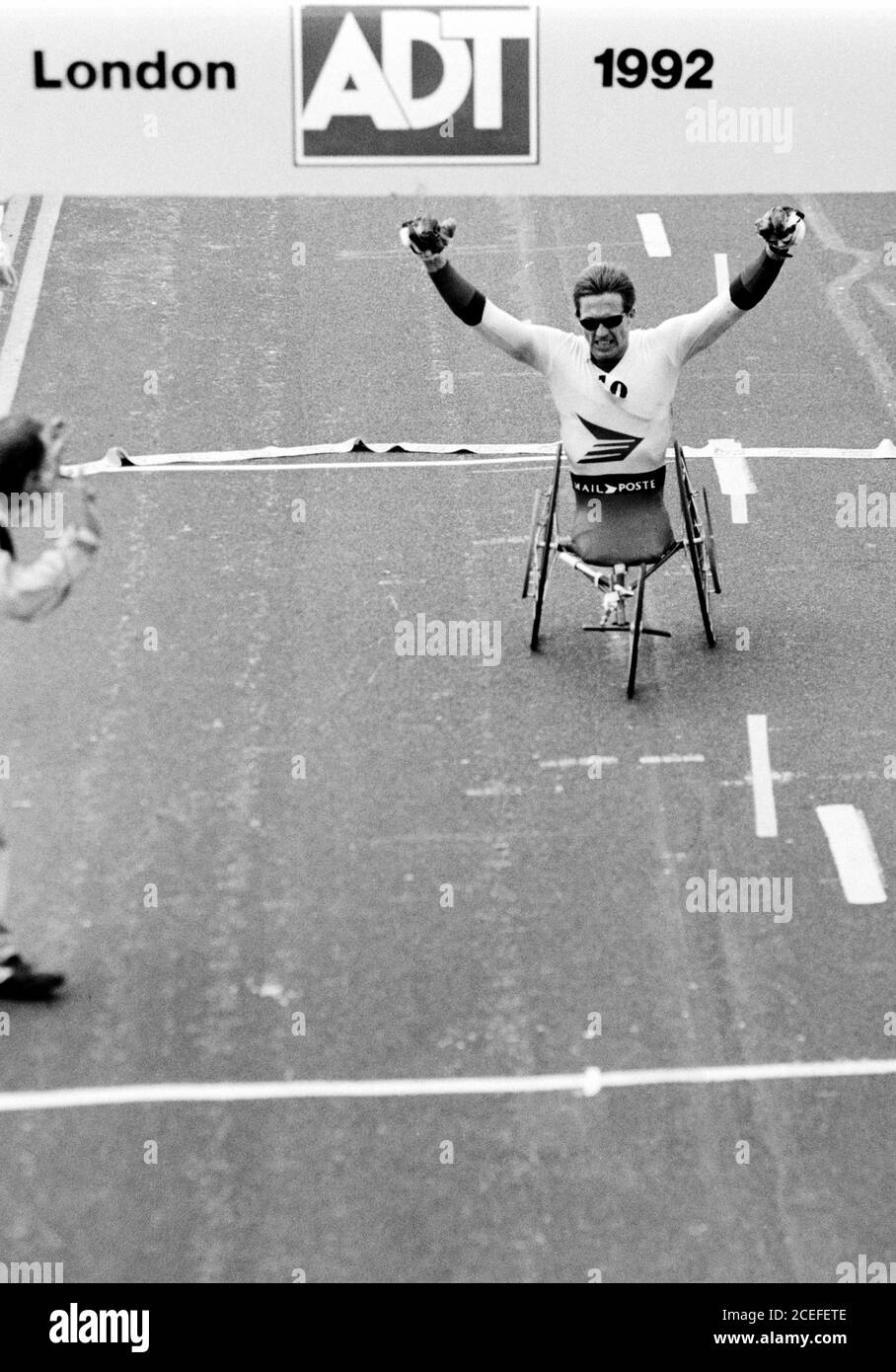 Daniel Wesley (CAN) crosses line to win the Men’s Wheelchair race at the ADT London Marathon on Westminster Bridge, London. 12 April 1992. Photo: Neil Turner Stock Photo