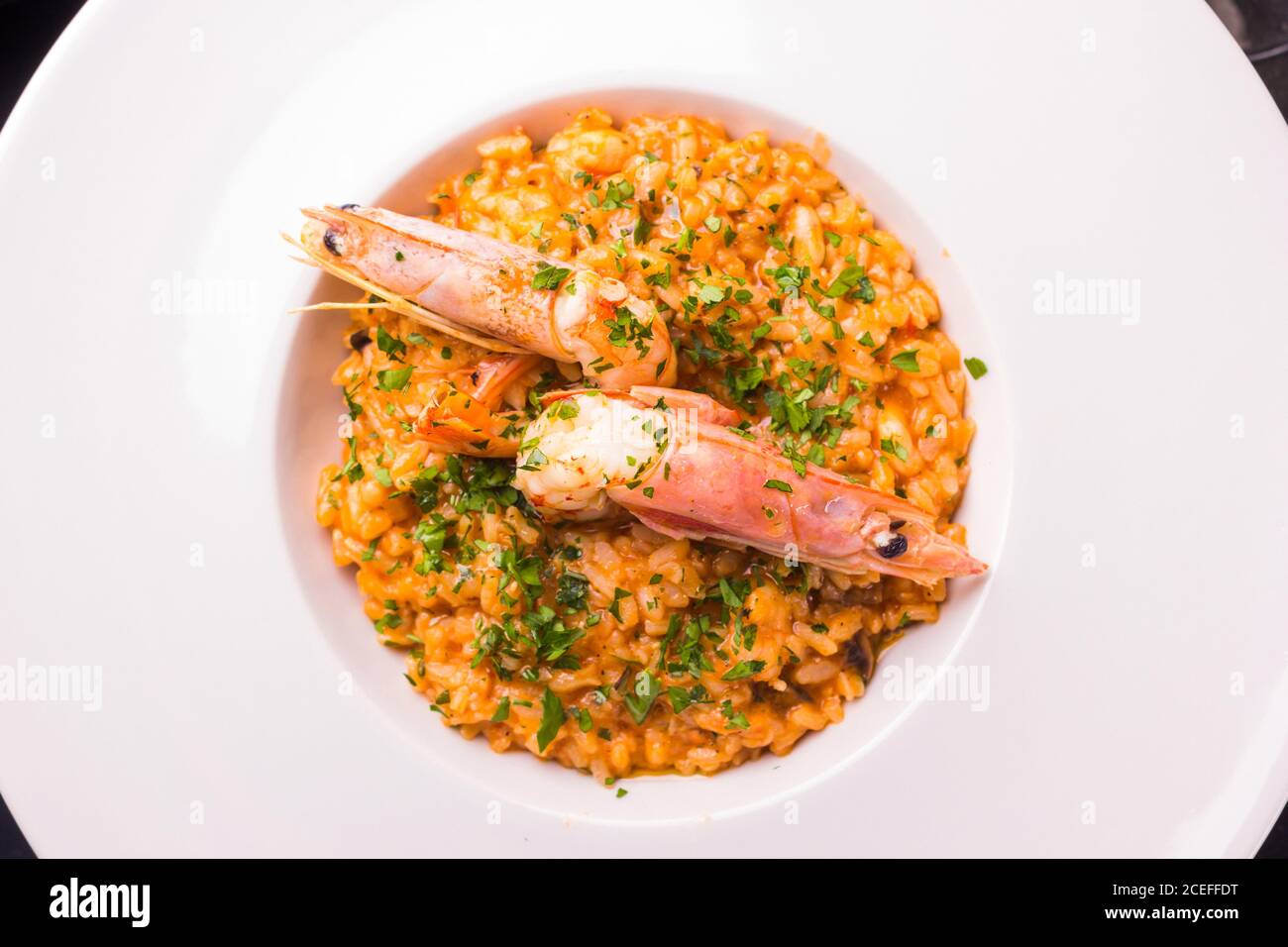 Elegant white ceramic plate with bright delicious risotto with shrimps ...