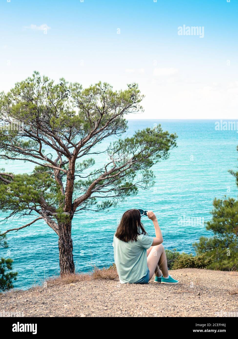 Woman sitting on cliff at hi-res stock photography and images - Alamy
