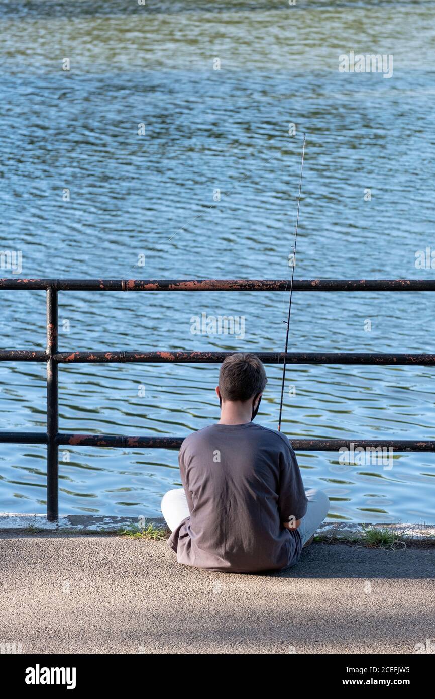 An unidentified young man fishes in the Lake at Kissena Park in Flushing, Queens, New York City. Stock Photo