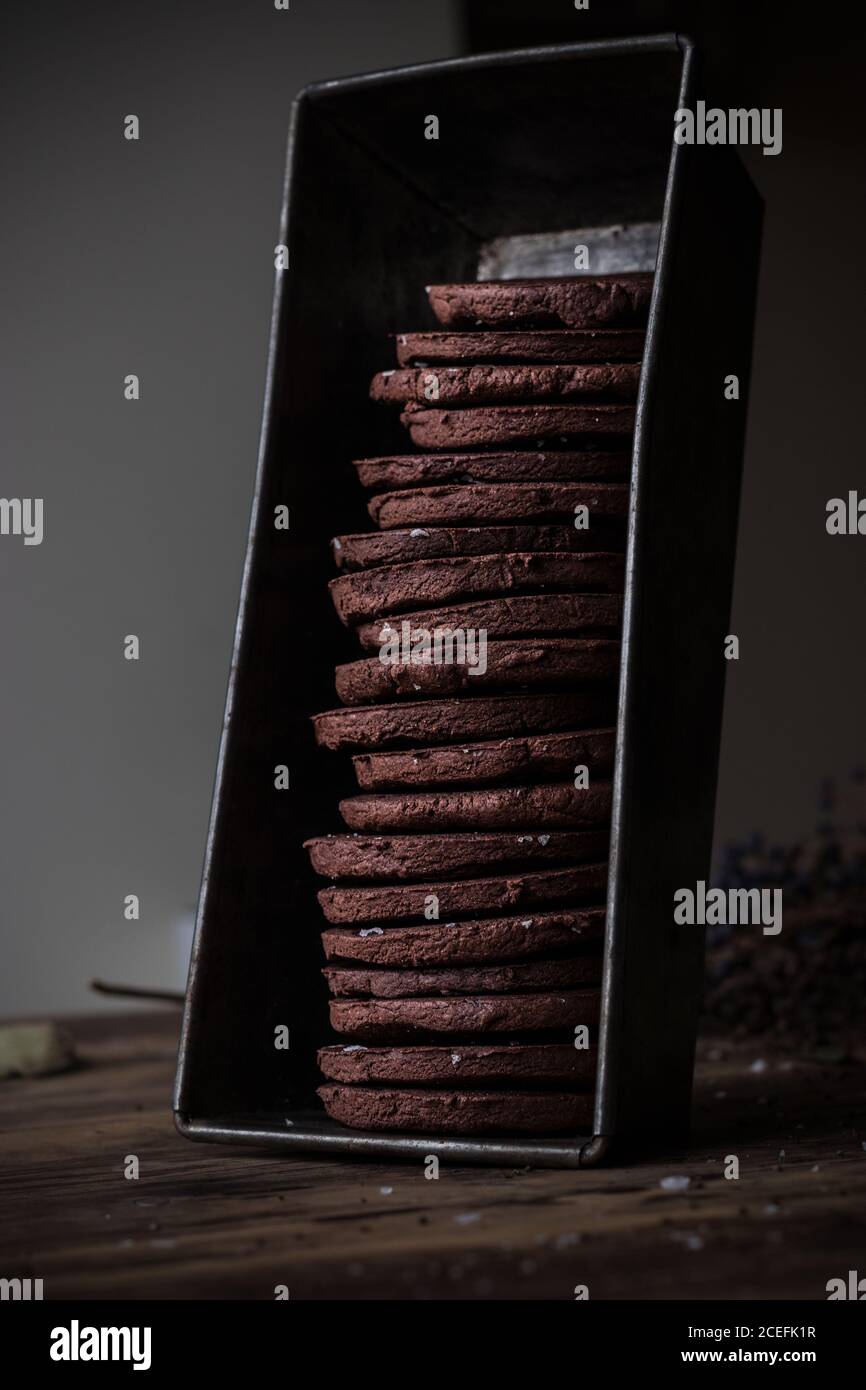 Metal container with stack of yummy gluten free chocolate cookies standing on old wooden table Stock Photo