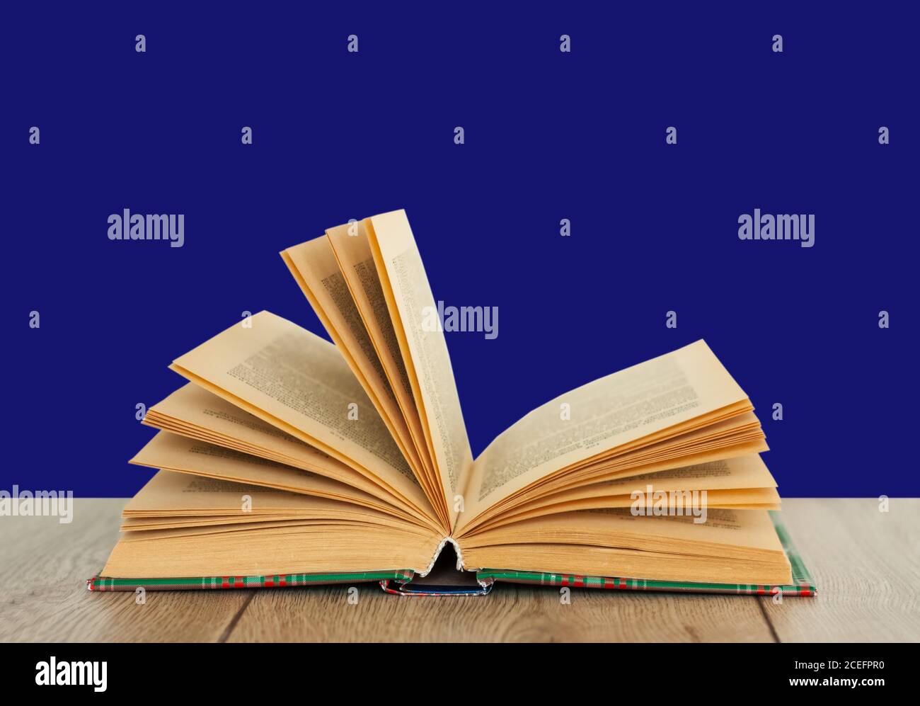 Open book textbook in colorful cover on a blue background. Back to school distance home education.Quarantine concept of stay home Stock Photo
