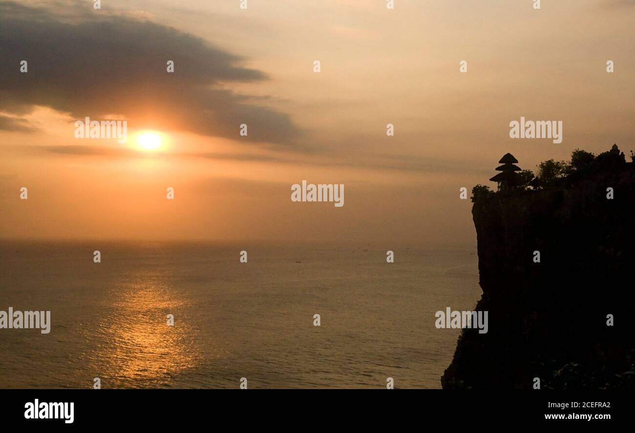 Sheer drop with building near picturesque ocean on beautiful sunrise in Indonesia Stock Photo