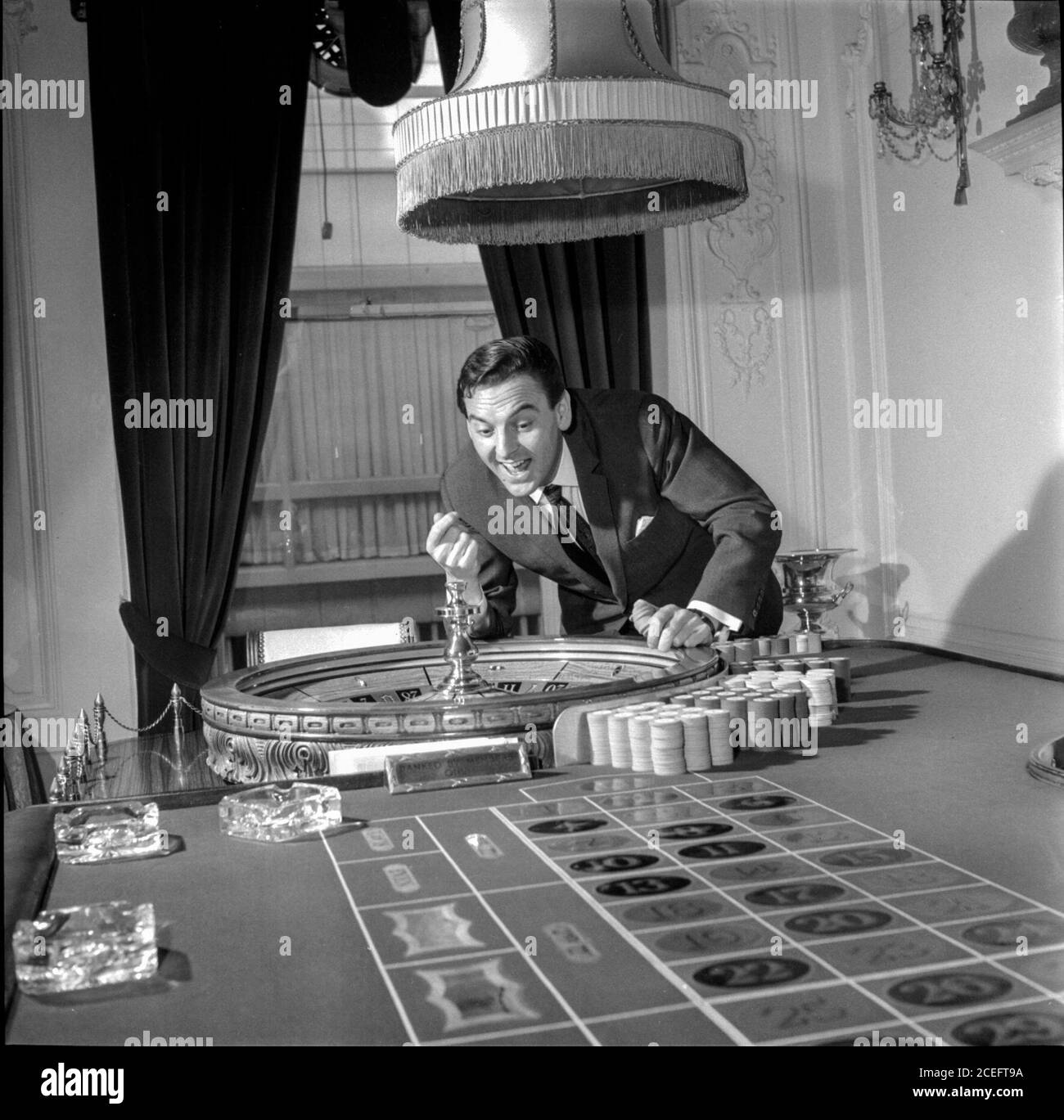 Comedian and television game show host Bob Monkhouse at home playing on his roulette table Stock Photo