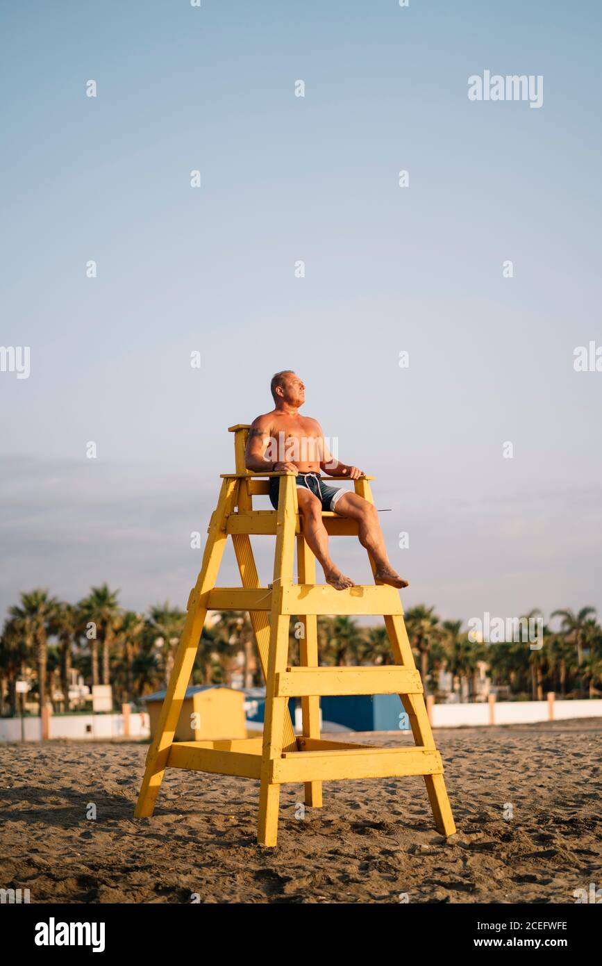 Strong man rescuer keeps watch on beach. Stock Photo