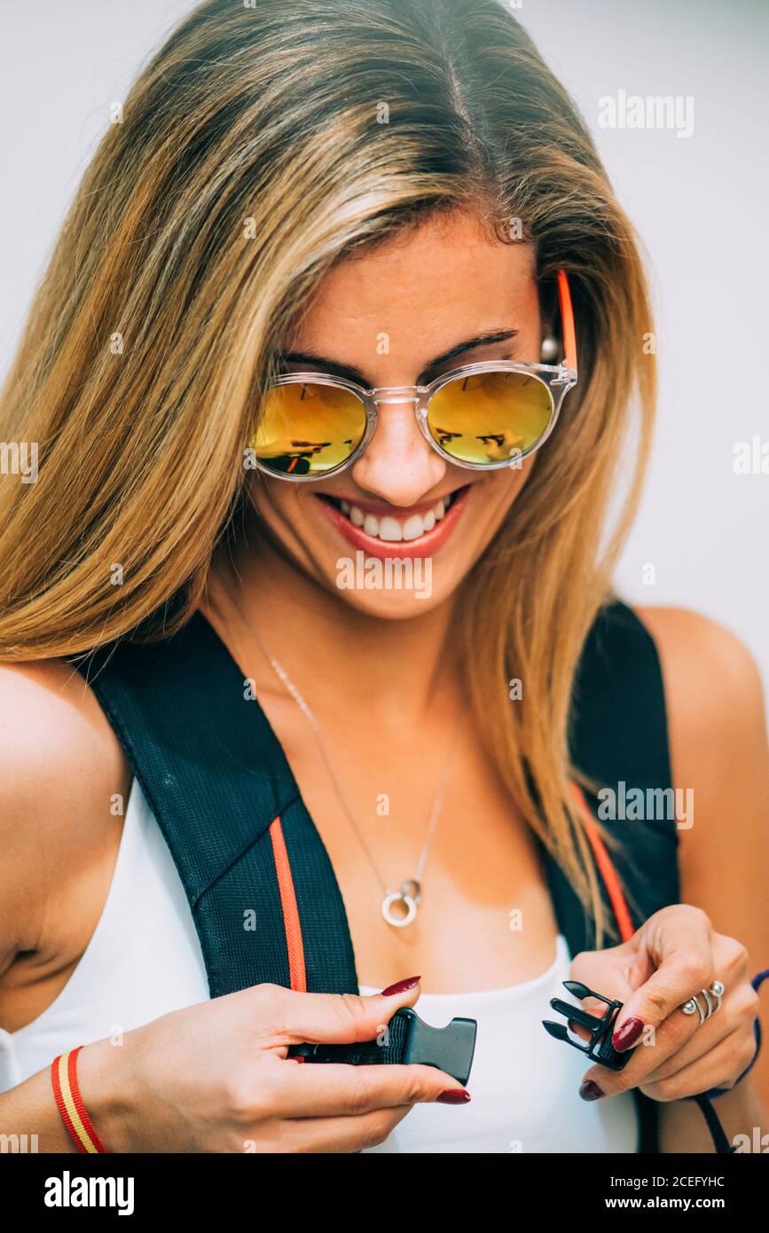 Young Woman touching backpack and laughing Stock Photo