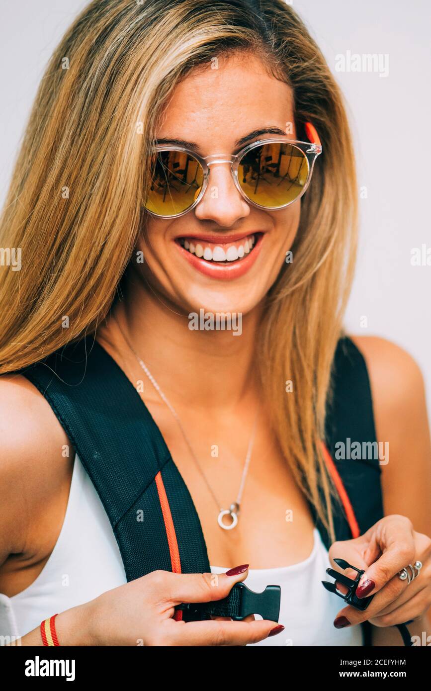 Young Woman touching backpack and laughing Stock Photo