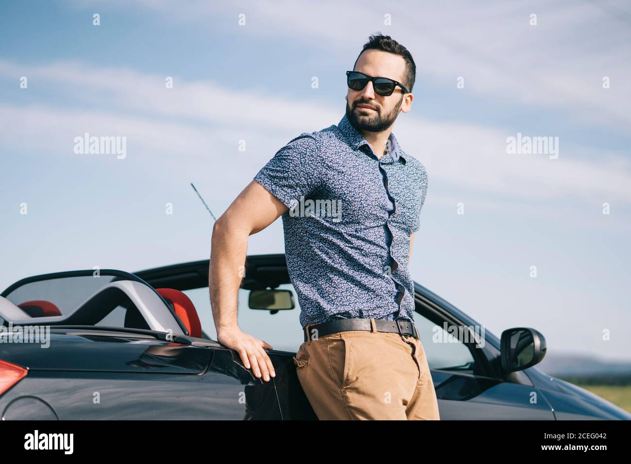 handsome stylish man in sunglasses smiling and posing in car Stock Photo -  Alamy
