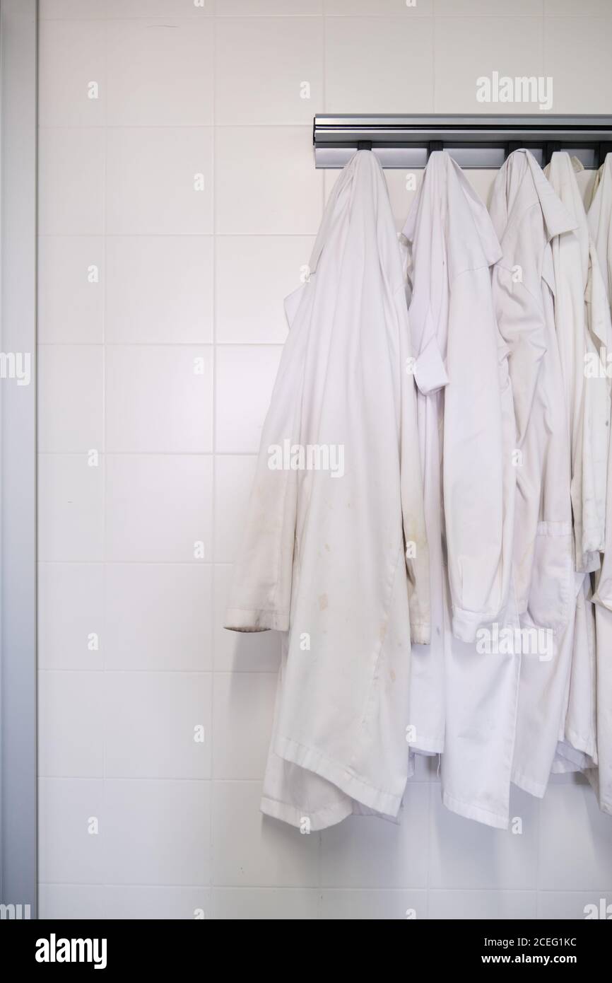 Dirty lab coats hanging in a laboratory. Research concept. Stock Photo