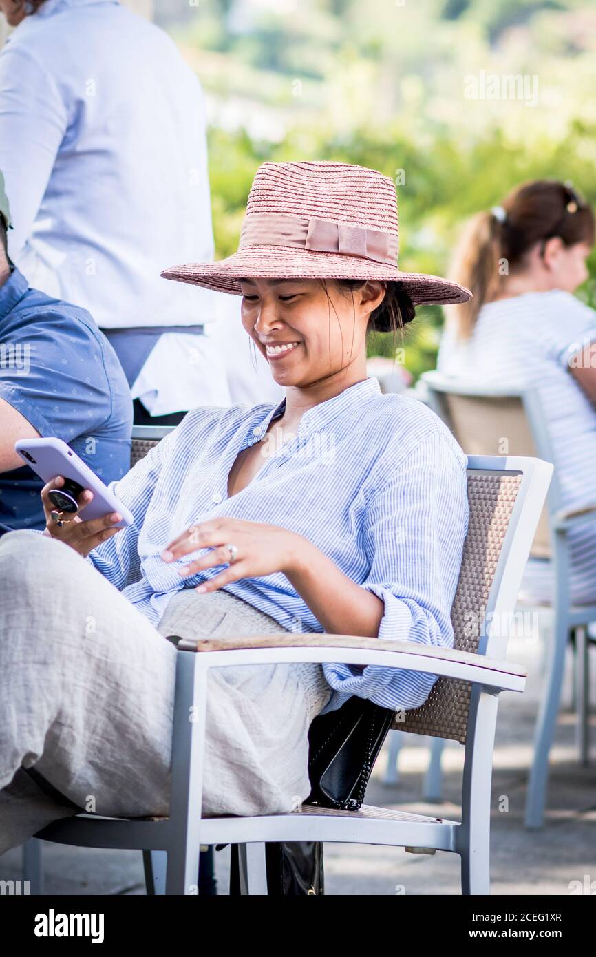 A beautiful stylish woman relaxes whilst on holiday in a  cafe in the Ravello town square, Italy. Stock Photo