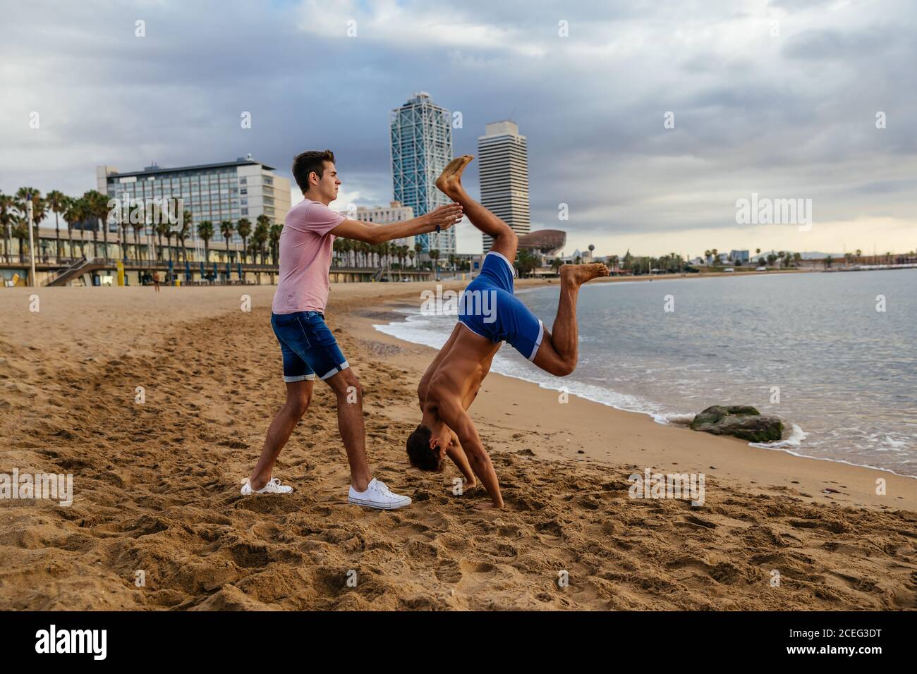 Two athletes do a handstand on the beach. Stock Photo