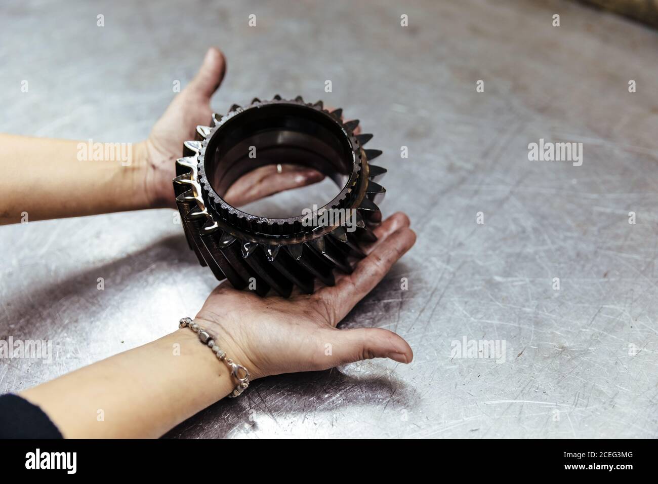 Woman with a piece of car engine Stock Photo