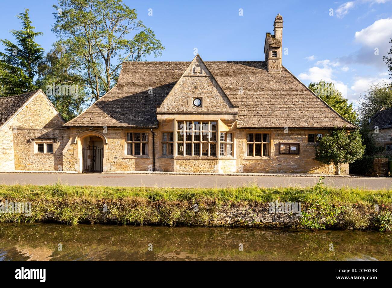 Evening light on the village hall beside the River Eye in the Cotswold village of Lower Slaughter, Gloucestershire UK Stock Photo
