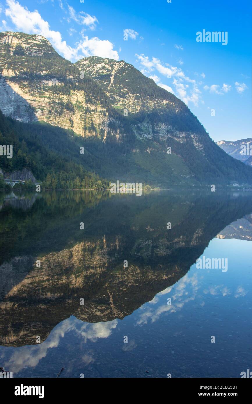 Mirror reflection in Hallstatter See,Austria. Summer spring colors lake and mountain in the background at sunrise in Austrian Alps.Beautiful peaceful Stock Photo