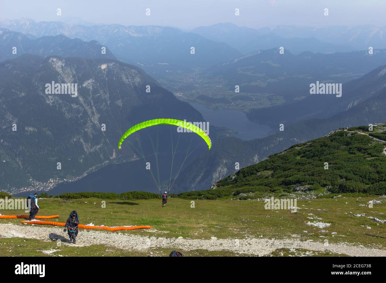A paraglider at the start of the Krippenstein mountain in the Dachstein area,Austria.Paraglide silhouette over Hallstatter See.Extreme adrenaline spor Stock Photo