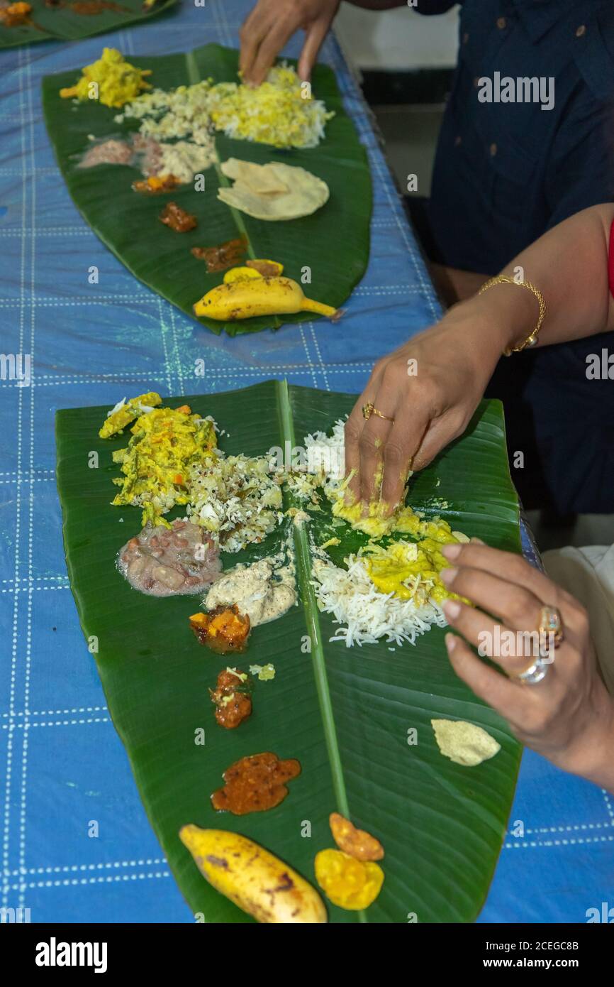 Traditional Kerala food being eaten on a banana leaf during the Onam festival in Kerala India Stock Photo