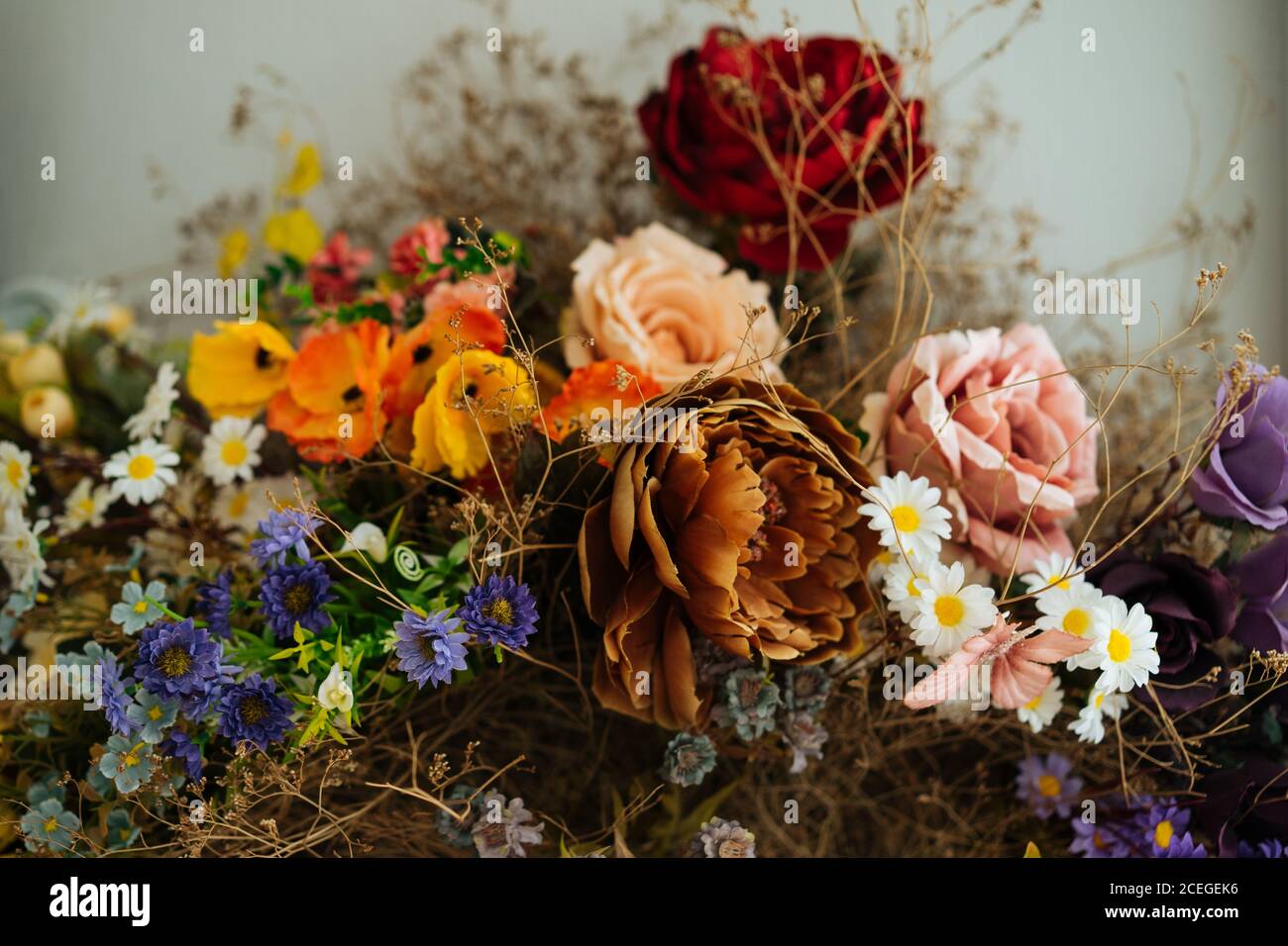 Elegant showy fresh roses and wildflowers picked with beautiful dried flowers and herbs tied up with black cord on grey background Stock Photo