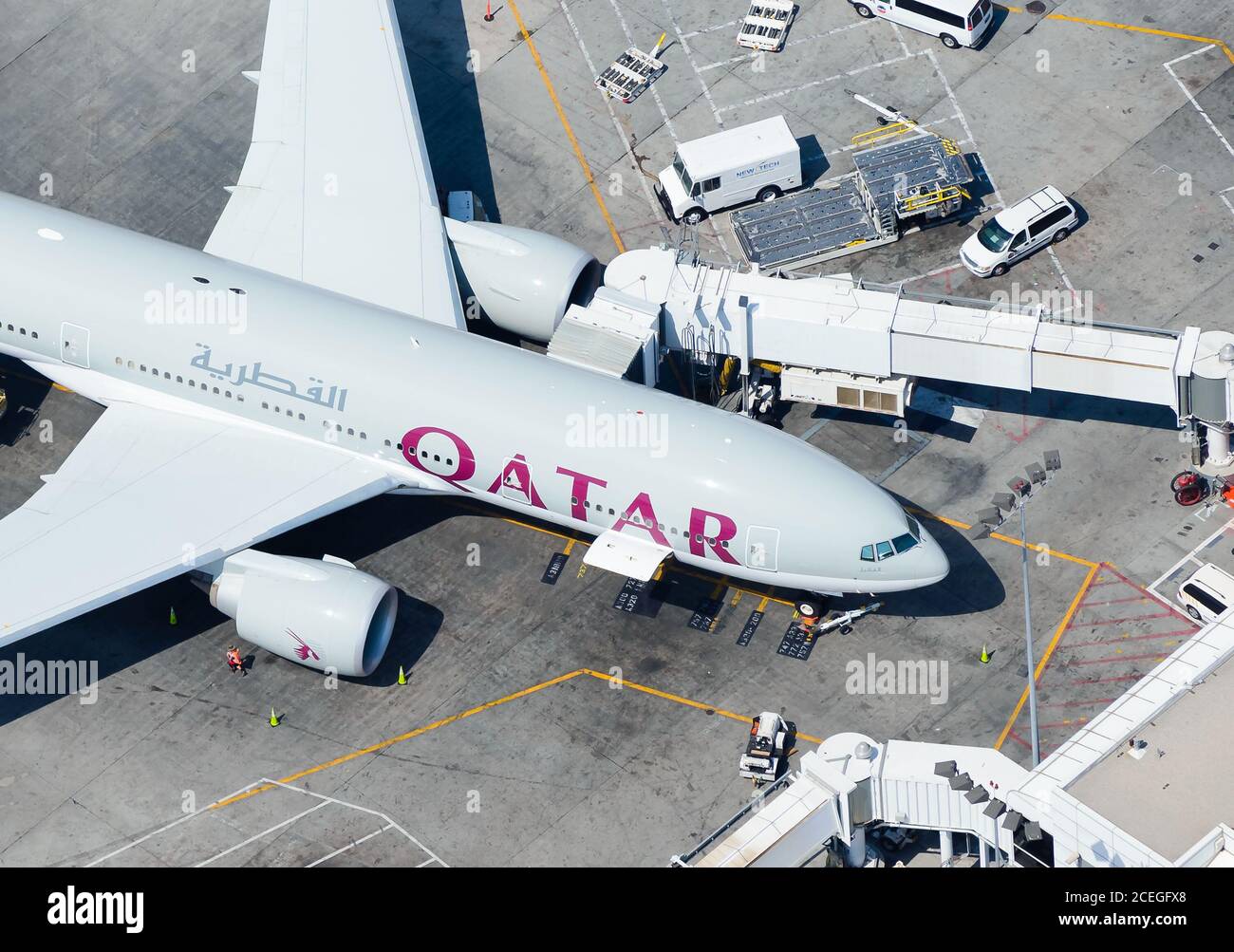 Qatar Airways Boeing 777 at Los Angeles (USA) Airport terminal connected to jet bridges for