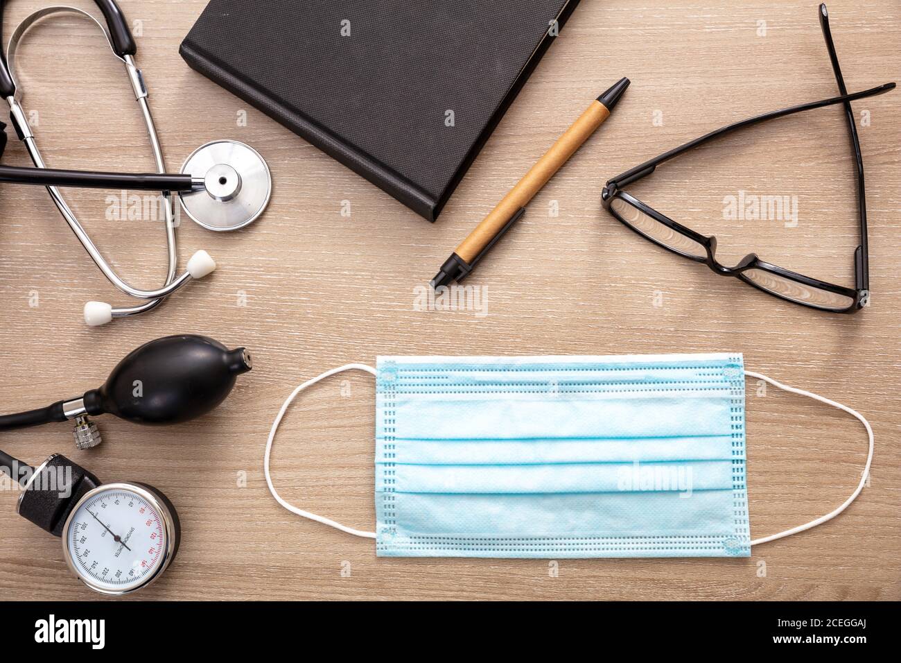 Medical stethoscope sphygmomanometer and protective mask on cardiologist doctor office desk. Coronavirus protection, healthcare concept, top view Stock Photo