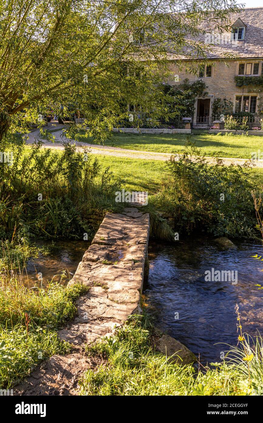 Evening light on an old stone bridge across the River Eye in the Cotswold village of Upper Slaughter, Gloucestershire UK Stock Photo