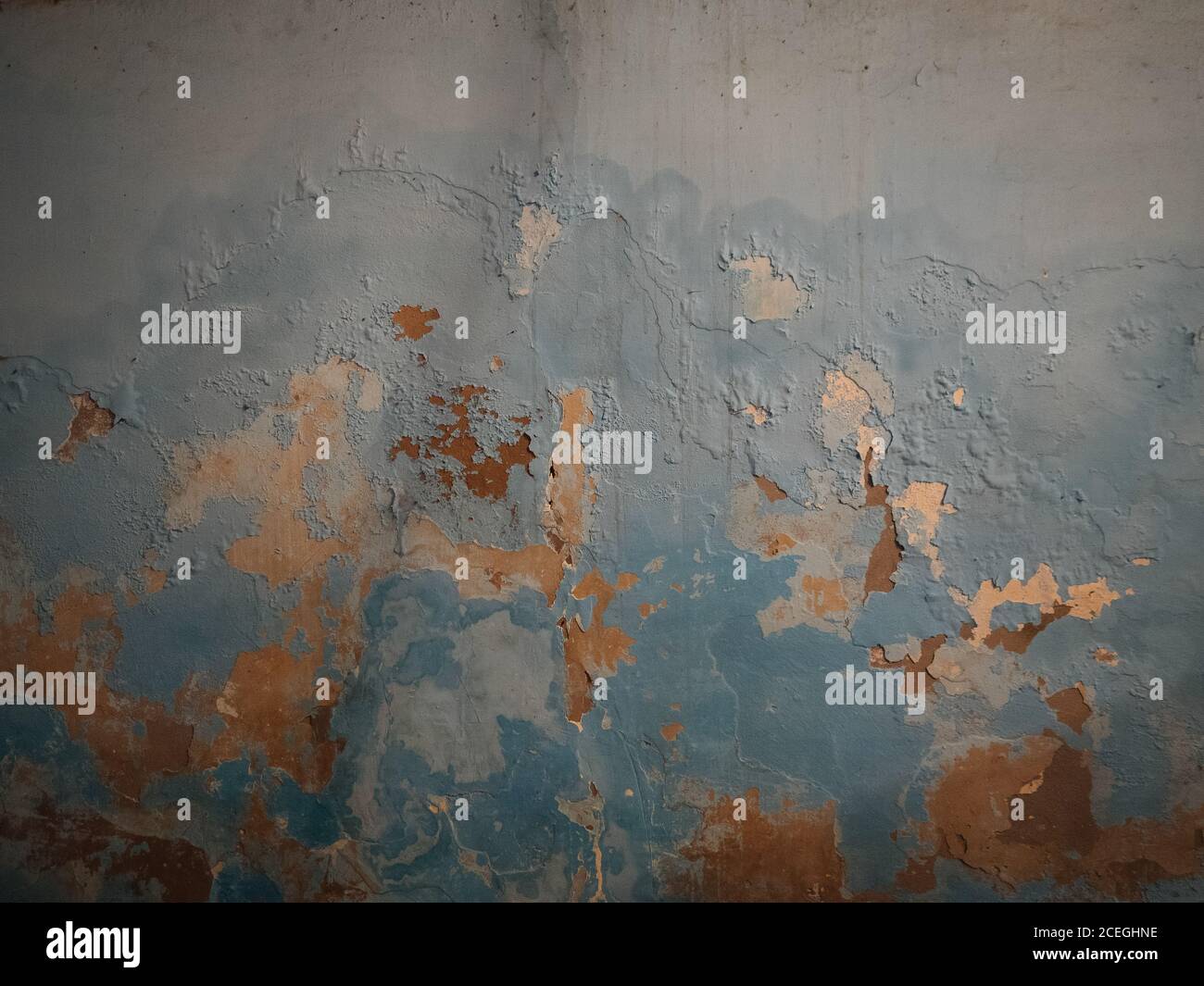 Background of exterior weathered wall with flakes of blue and orange