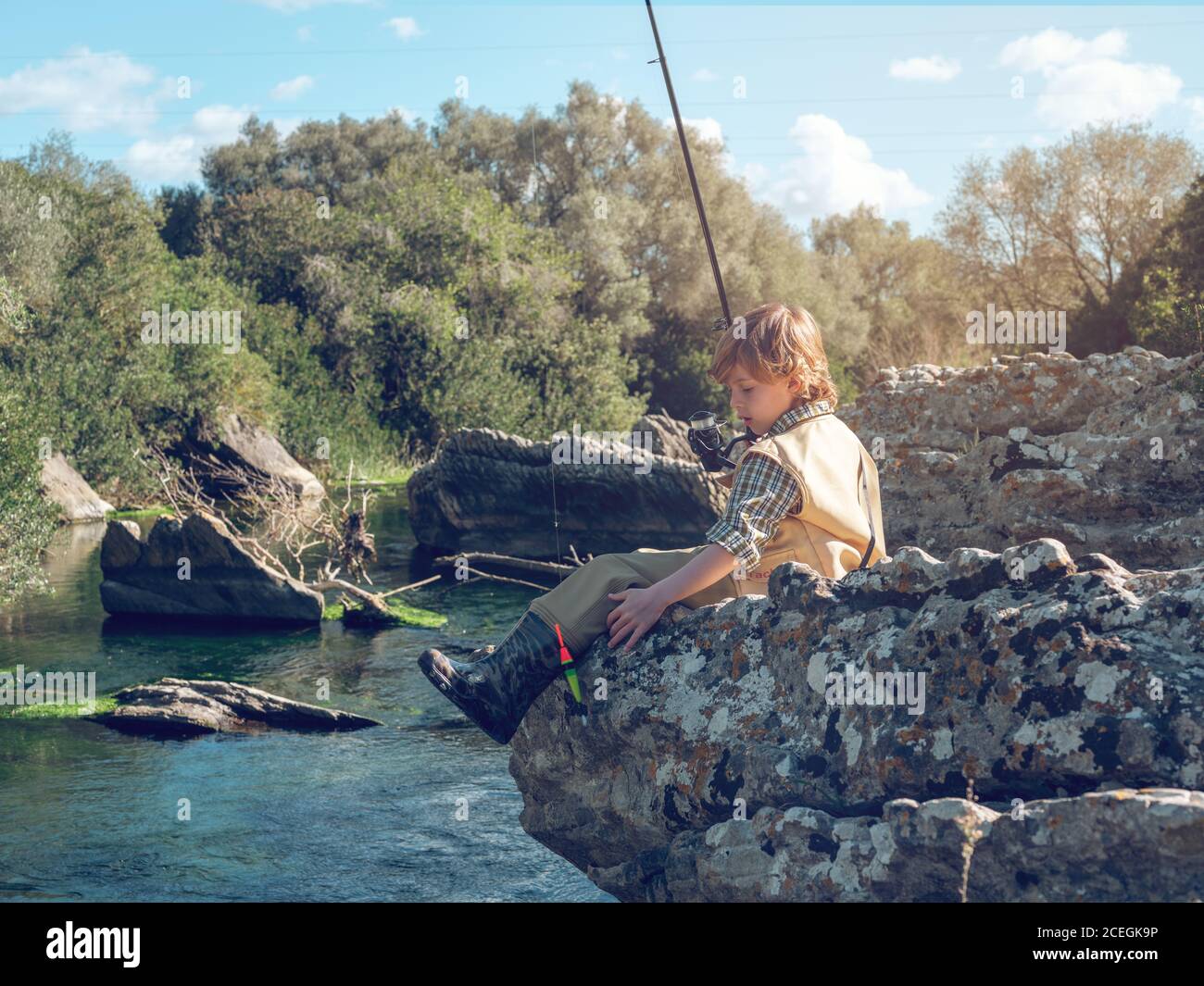Young boy sitting and fishing Stock Photo