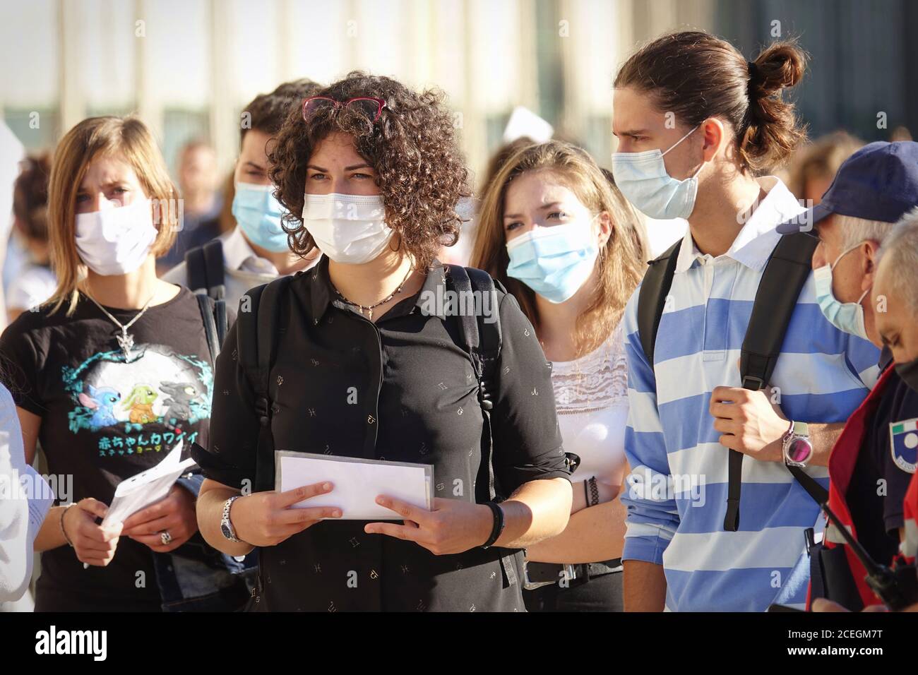 Students queuing at the school entrance wearing mask face to prevent infection or respiratory illness. Turin, Italy - September 2020 Stock Photo